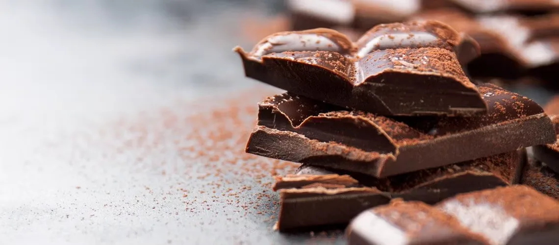 Pedaços de chocolate escuro sobre uma superfície de madeira