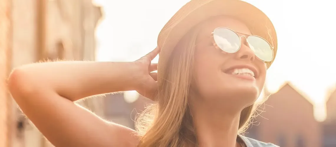 Mulher de óculos escuros sorrindo em um dia ensolarado